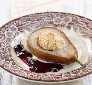 Pears, filled with meringue on a placed on almond cream and light blueberry confiture